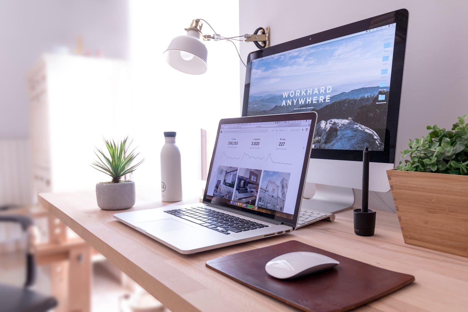 Bureau avec un ordinateur portable et un écran, prêt pour une journée de rédaction